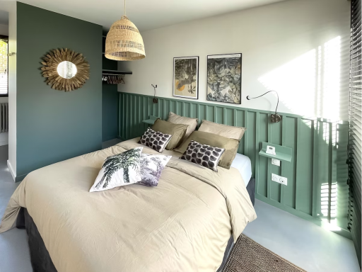 Chambre moderne avec lit, oreillers décoratifs et murs verts. Éclairage naturel.